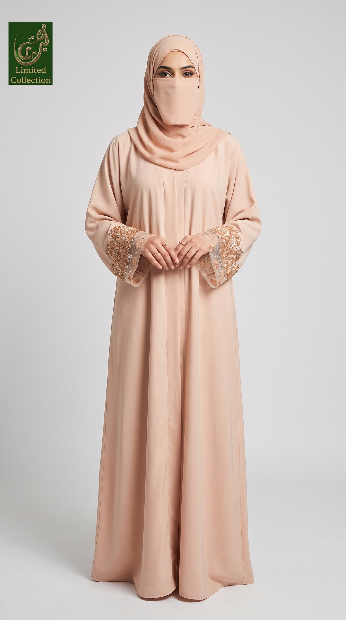 A woman modeling a peach-colored abaya and matching hijab against a light gray studio background. The abaya has embroidered lace details on the sleeves, and a green 'Abayat Limited Collection' logo is visible in the top-left corner.