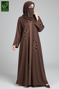 a woman is seen wearing a beautiful brown tissue  cutwork handmade abaya.