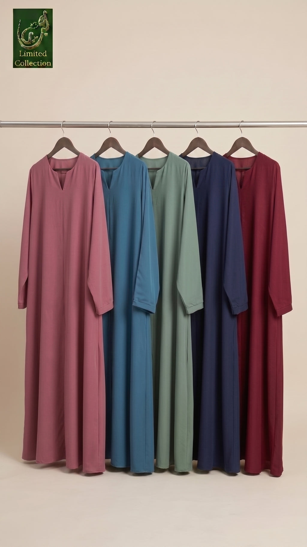 Five long-sleeve modest front open abayas in dusty pink, teal blue, sage green, navy blue, and burgundy red hang on a metal rack against a warm beige background. A green 'Limited Collection' logo is visible in the top left corner.
