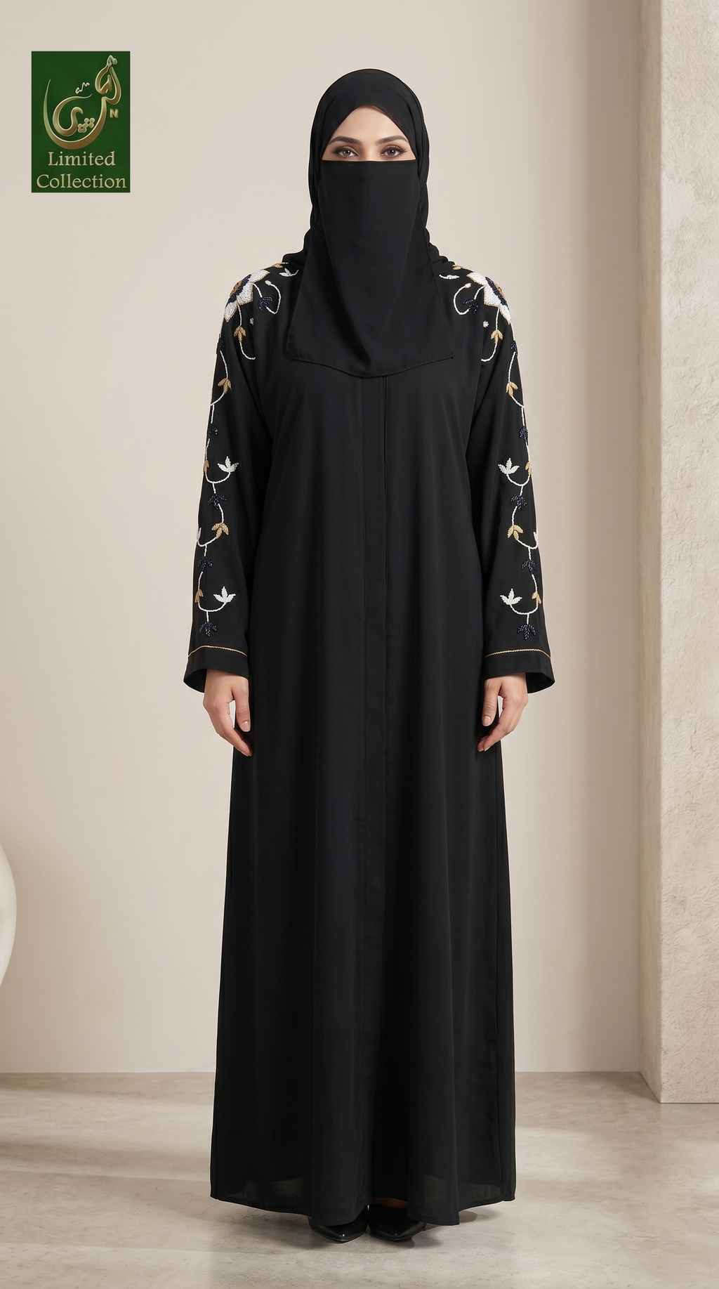 A woman wearing a black abaya with floral embroidery on the sleeves and a matching black hijab, standing in a neutral indoor setting. A green 'Ghadeer Limited collections' logo is visible in the top-left corner.