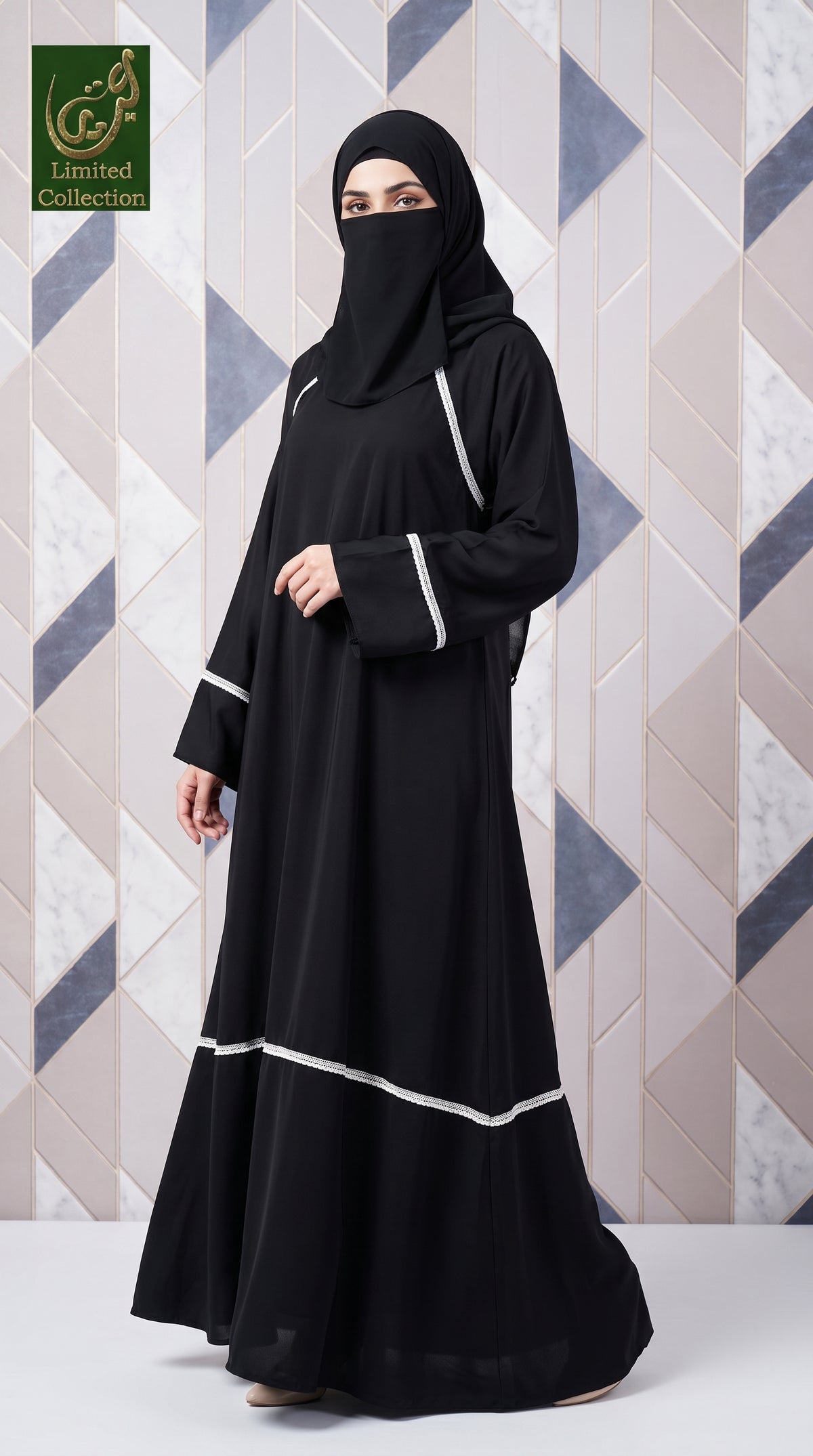 A woman wearing a black full-length abaya with white lacing details and a matching black hijab, standing against a geometric patterned wall. A logo for 'Limited Collection' is visible in the top-left corner.
